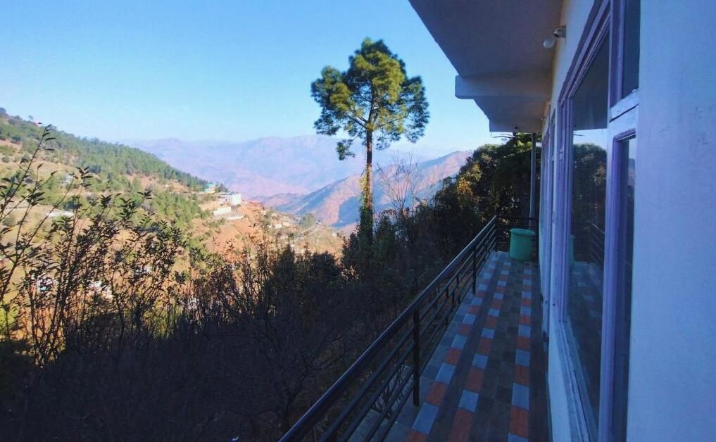 A balcony with a view of a valley and mountains.