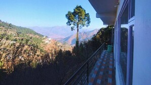 Un balcón con vistas a un valle y montañas.