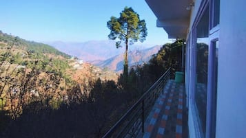 A balcony with a view of a valley and mountains.