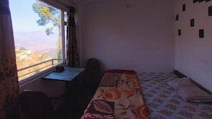 Una habitación con una cama, un escritorio y una ventana.