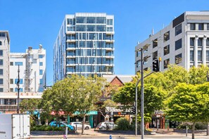 A modern urban street with multi-story buildings, a visible restaurant, and parked cars. - Wellington CBD 3BR with Pool, Gym & Views (Wellington)