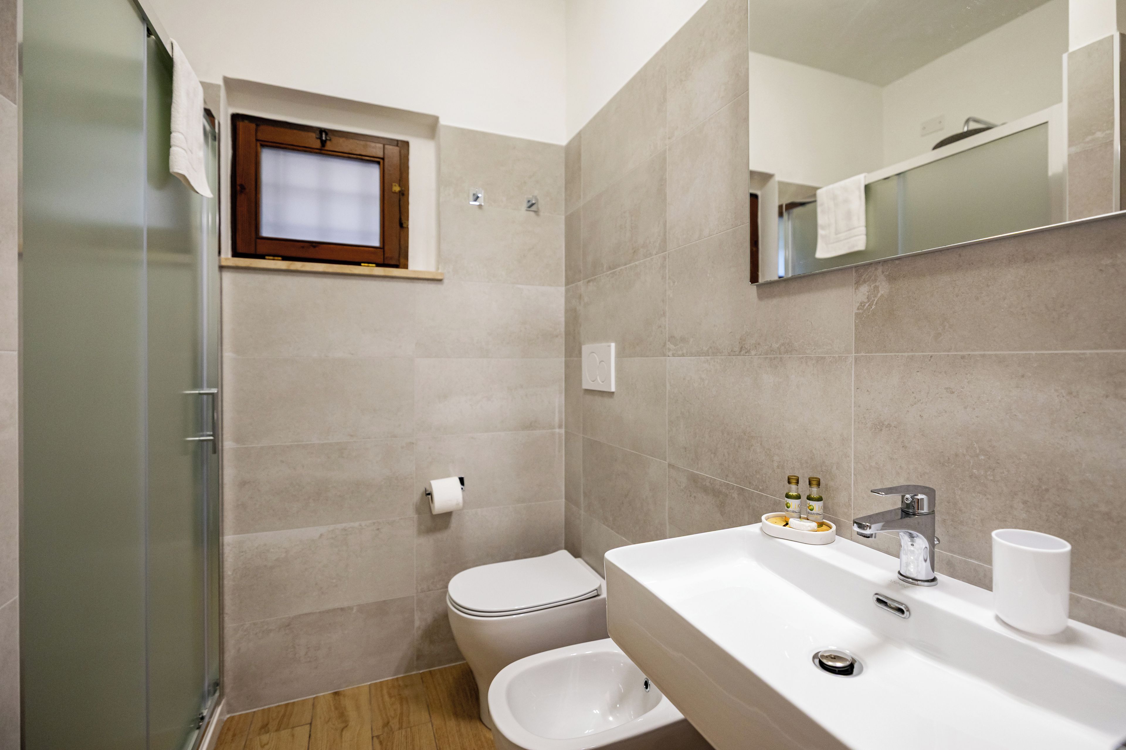 Ein Badezimmer mit Toilette, Bidet und Waschbecken mit Spiegel darüber.