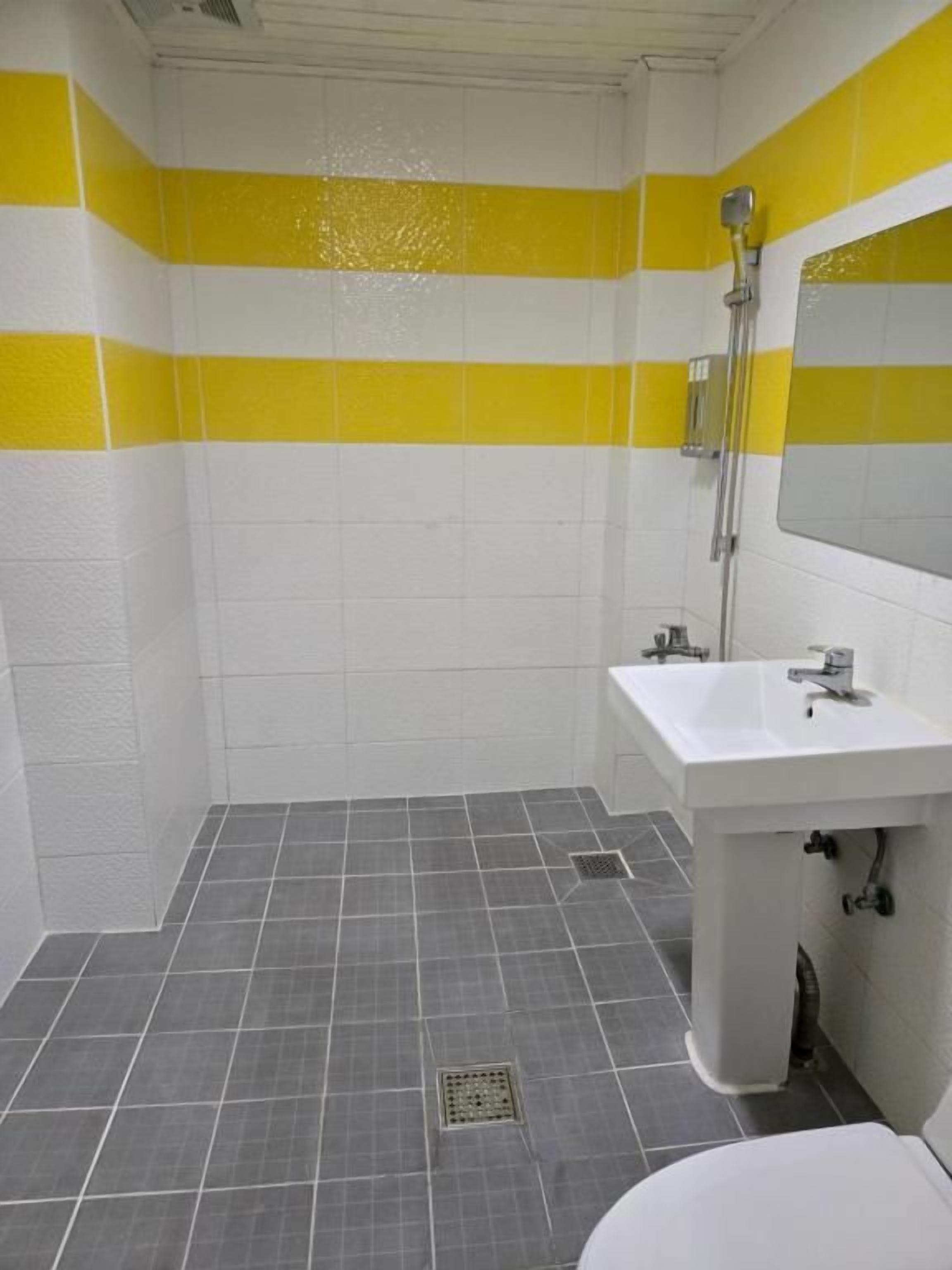A bathroom with a shower, sink, and toilet.