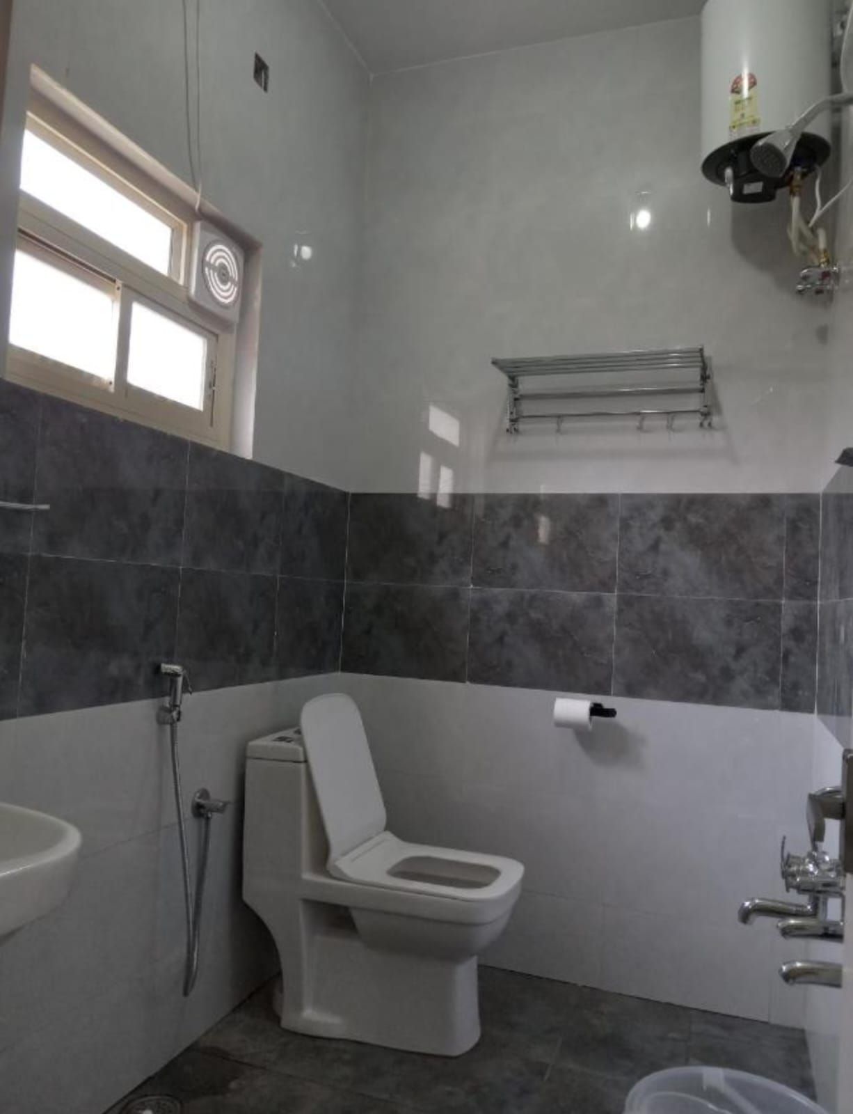 A bathroom with a toilet, sink, and shower.