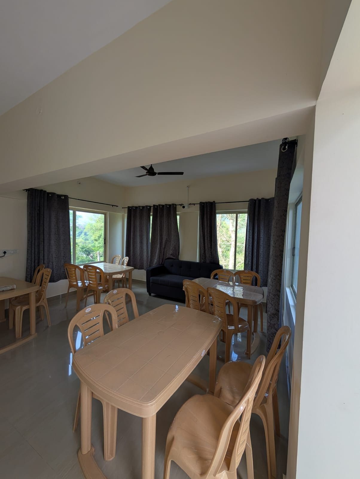Una habitación con una mesa de comedor, sillas, un sofá y un ventilador de techo.