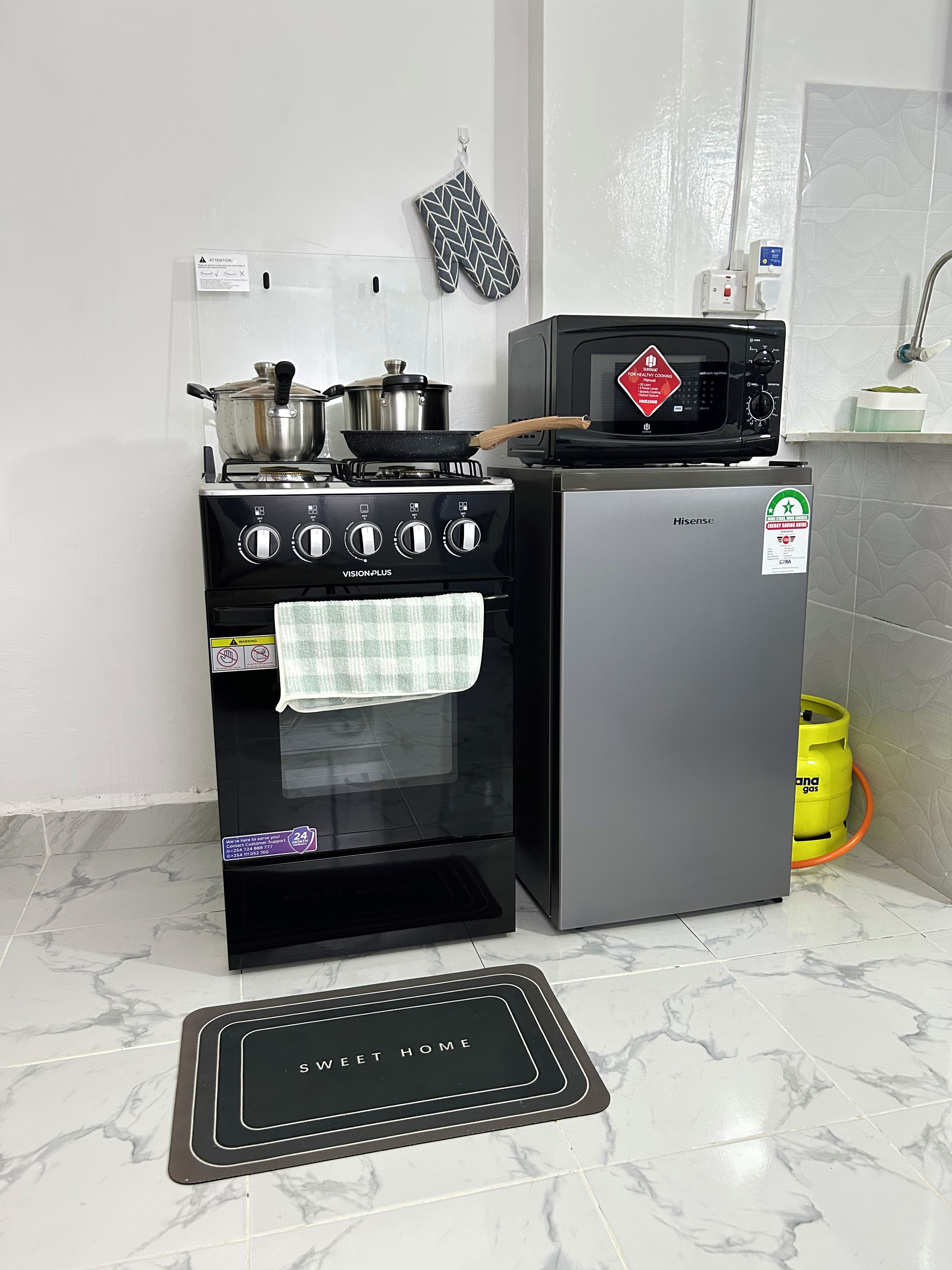 A kitchen with a stove, oven, microwave, and a Hisense refrigerator.
