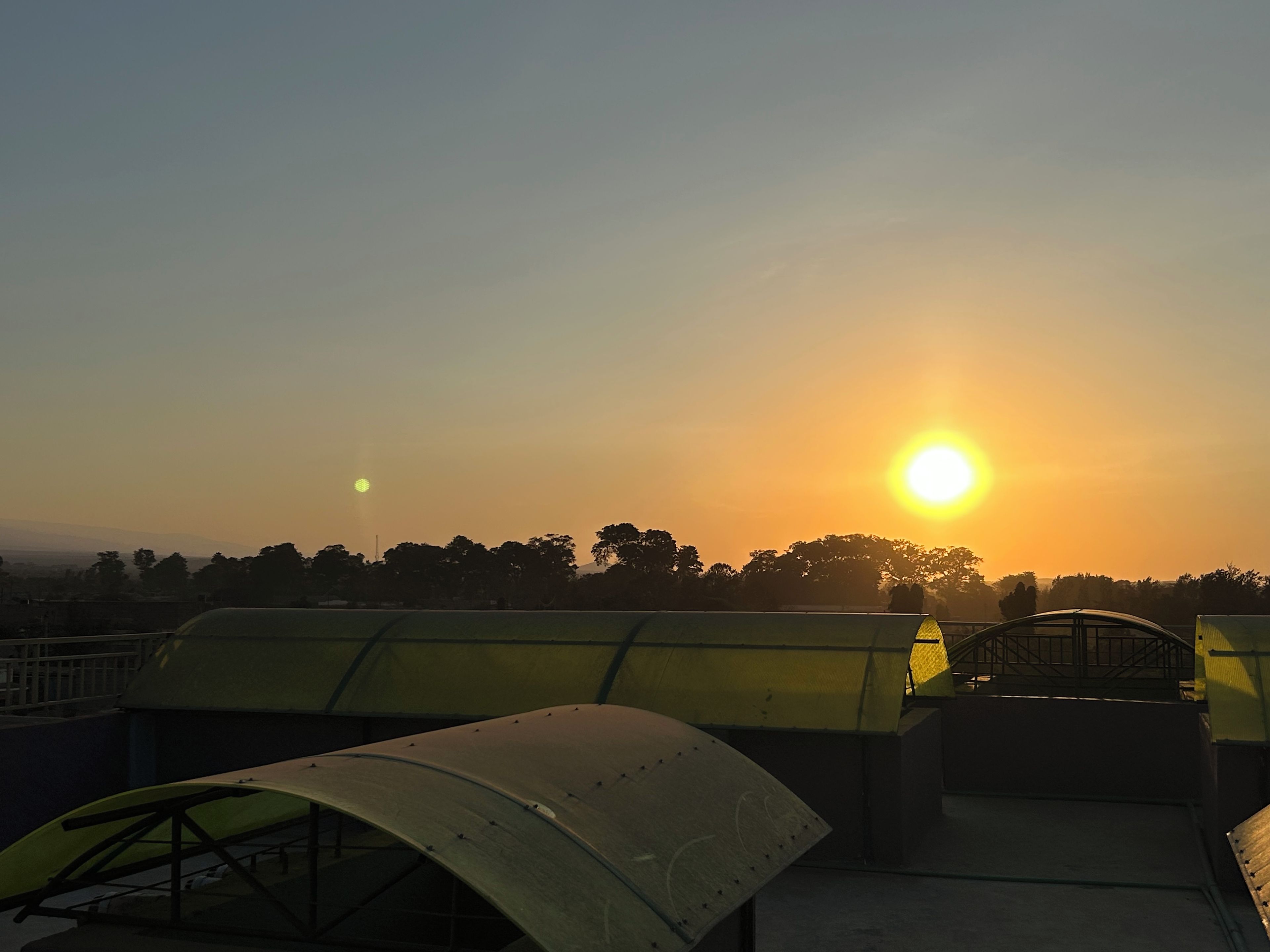 Ein Sonnenuntergang über einer Brücke bei klar blauem Himmel.