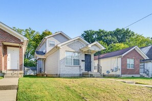 A residential neighborhood with single-family homes featuring front porches, brick facades, and a well-maintained lawn.