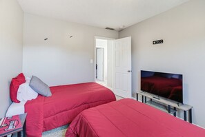 A room with two beds, a television, and a door leading to another room. - Derby House - Louisville (Louisville)