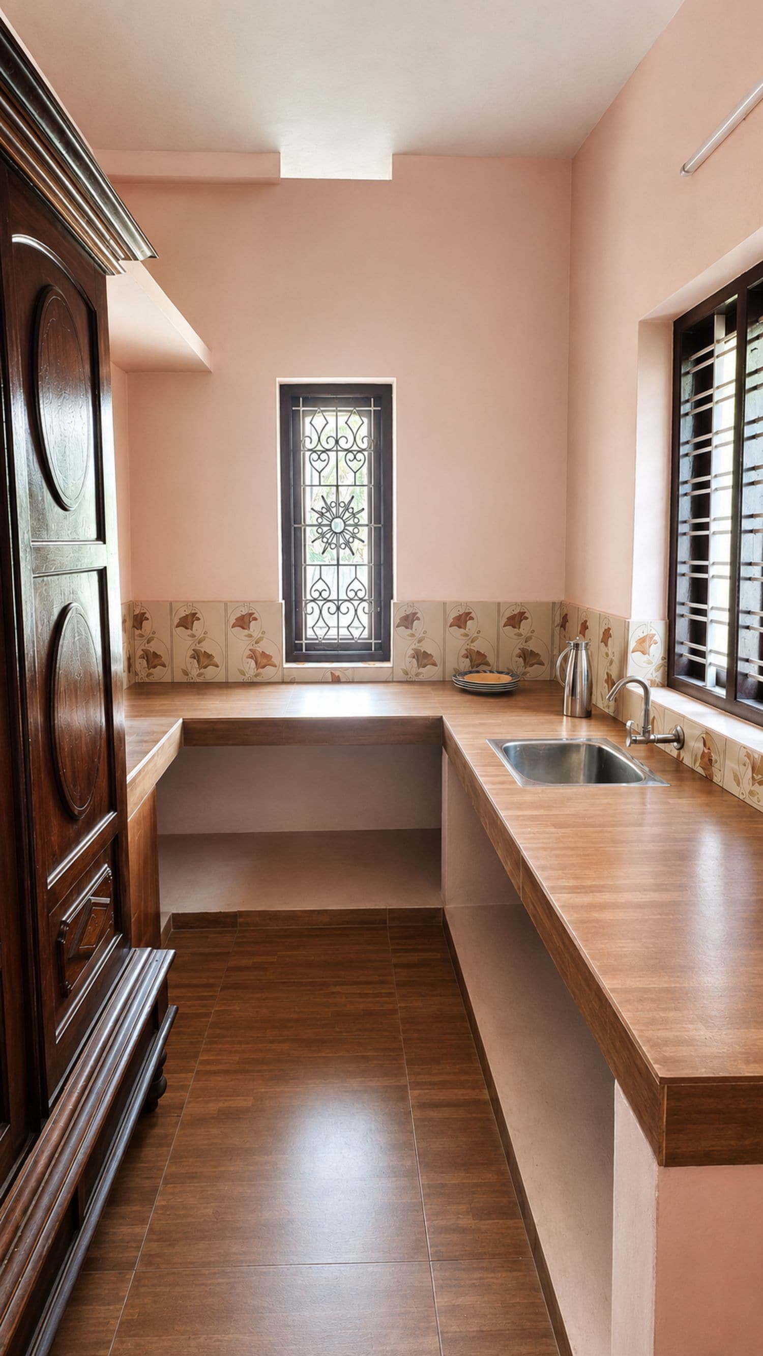 A kitchen with a wooden countertop, a stainless steel sink, and a decorative window.