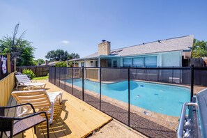 A backyard with a swimming pool, deck chairs, and a covered patio area. - Family-Friendly Home w/ Hot Tub in San Antonio! (San Antonio)