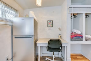 A compact kitchenette with a refrigerator, a small table, and a chair. - < 2 Mi to Raymond James Stadium! Couple’s Retreat (Tampa)