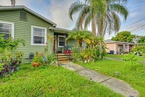 A green house with a porch, steps, and a small garden with palm trees. - < 2 Mi to Raymond James Stadium! Couple’s Retreat (Tampa)