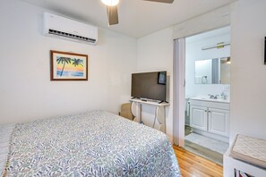 A bedroom with a bed, a television, and a bathroom visible through an open door. - < 2 Mi to Raymond James Stadium! Couple’s Retreat (Tampa)