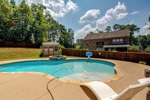 Ein Garten mit Swimmingpool, Whirlpool und einer Holzterrasse.