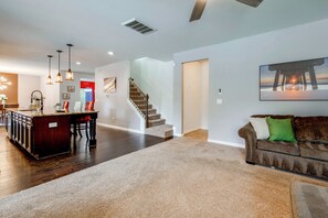 A spacious living area with a kitchen, a staircase, and a dining area. - McDonough Group Getaway: Pool, Patio + Game Room (McDonough)