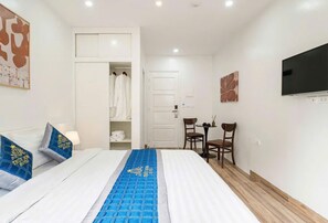 A hotel room with a bed, a wardrobe, a seating area, and a television. - Thuy Dung Hotel (Tu Liem)