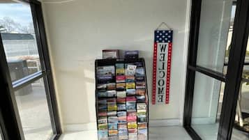 A display rack with various travel books and a 'WELCOME' sign with an American flag design.
