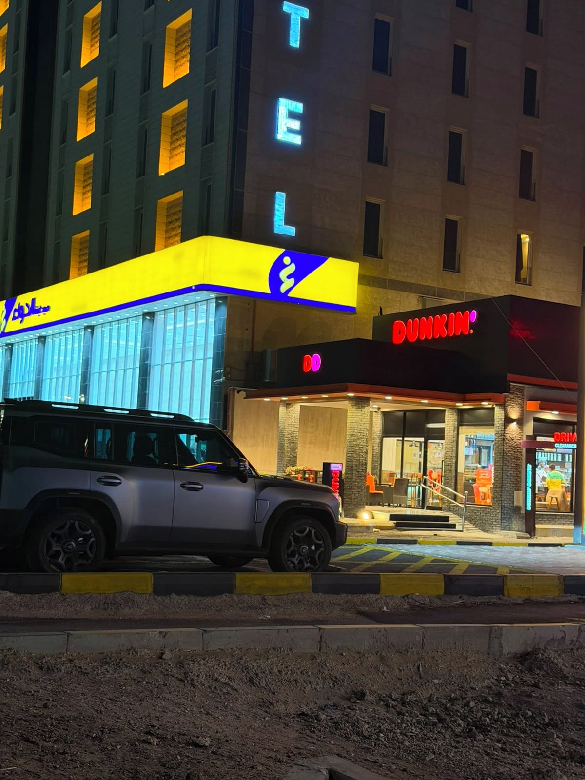Un edificio con un letrero visible de 'DUNKIN'' y un letrero de 'TEL' encima.