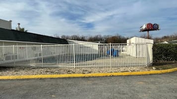 A fenced parking area with a building in the background.