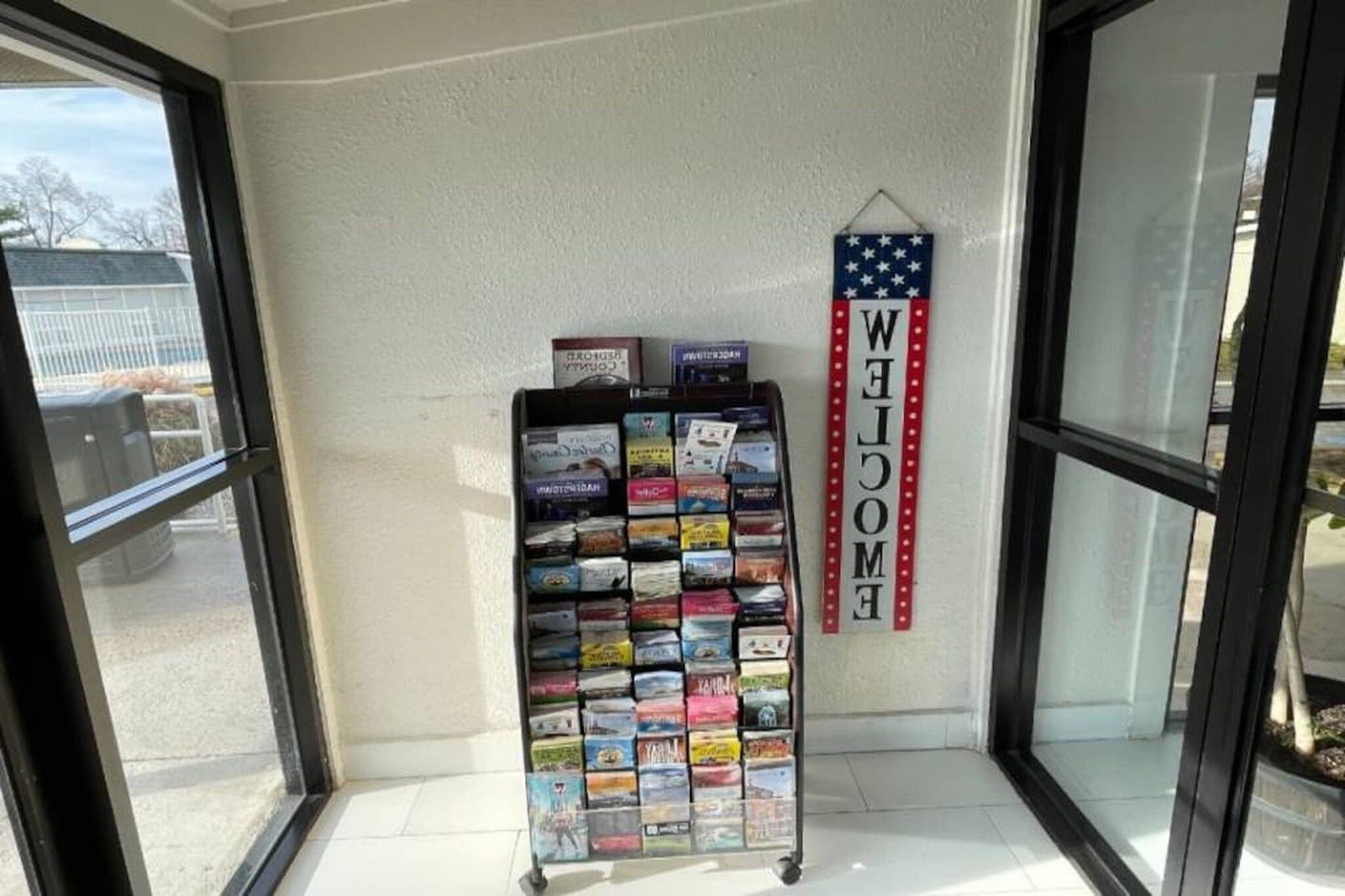 A display rack with various travel guides and a 'WELCOME' sign with stars.
