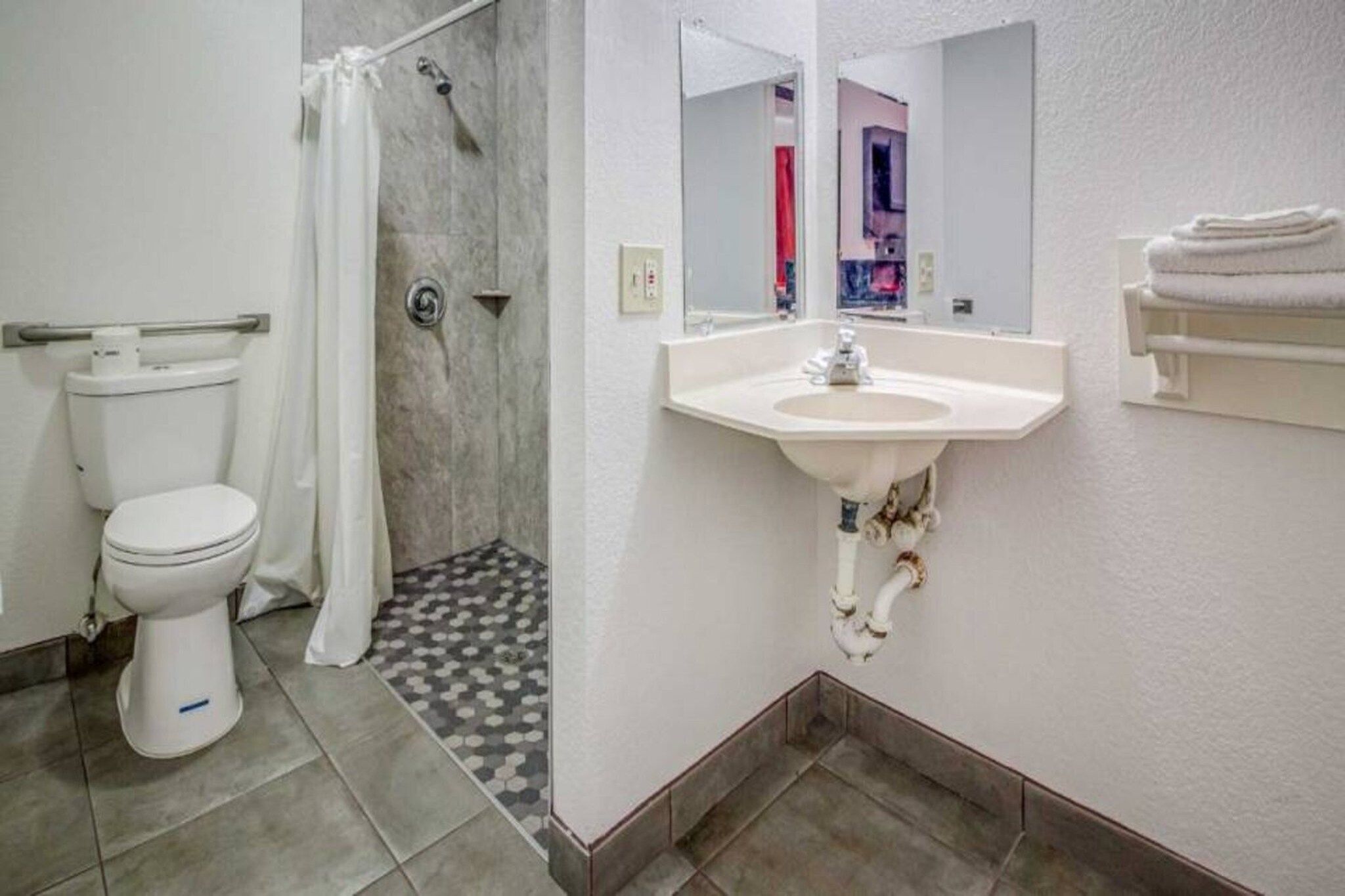 Ein Badezimmer mit Toilette, Dusche, Waschbecken und Spiegel.