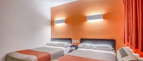 A hotel room with two beds, a wall-mounted air conditioner, and a red curtain.
