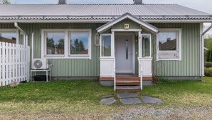 A single-story house with a front porch, a small step leading to the door, and a white picket fence. - Viinijärvi d 9 by Interhome (Liperi)