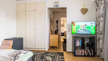 Makuuhuone, jossa on sänky, televisio, kirjahylly ja vaatekaappi.