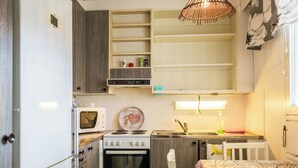 A compact kitchenette with a microwave, stove, and sink. - Viinijärvi d 9 by Interhome (Liperi)