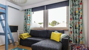 A room with a grey sofa, a yellow throw blanket, a blue ladder, and a colorful rug. - Viinijärvi d 10 by Interhome (Liperi)