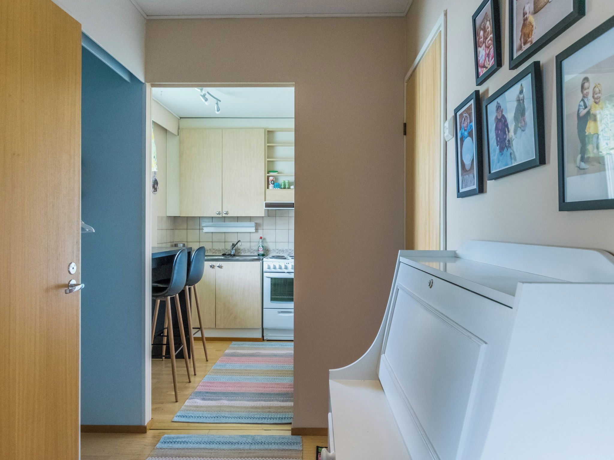Een moderne keuken met een fornuis, spoelbak en barstoelen.