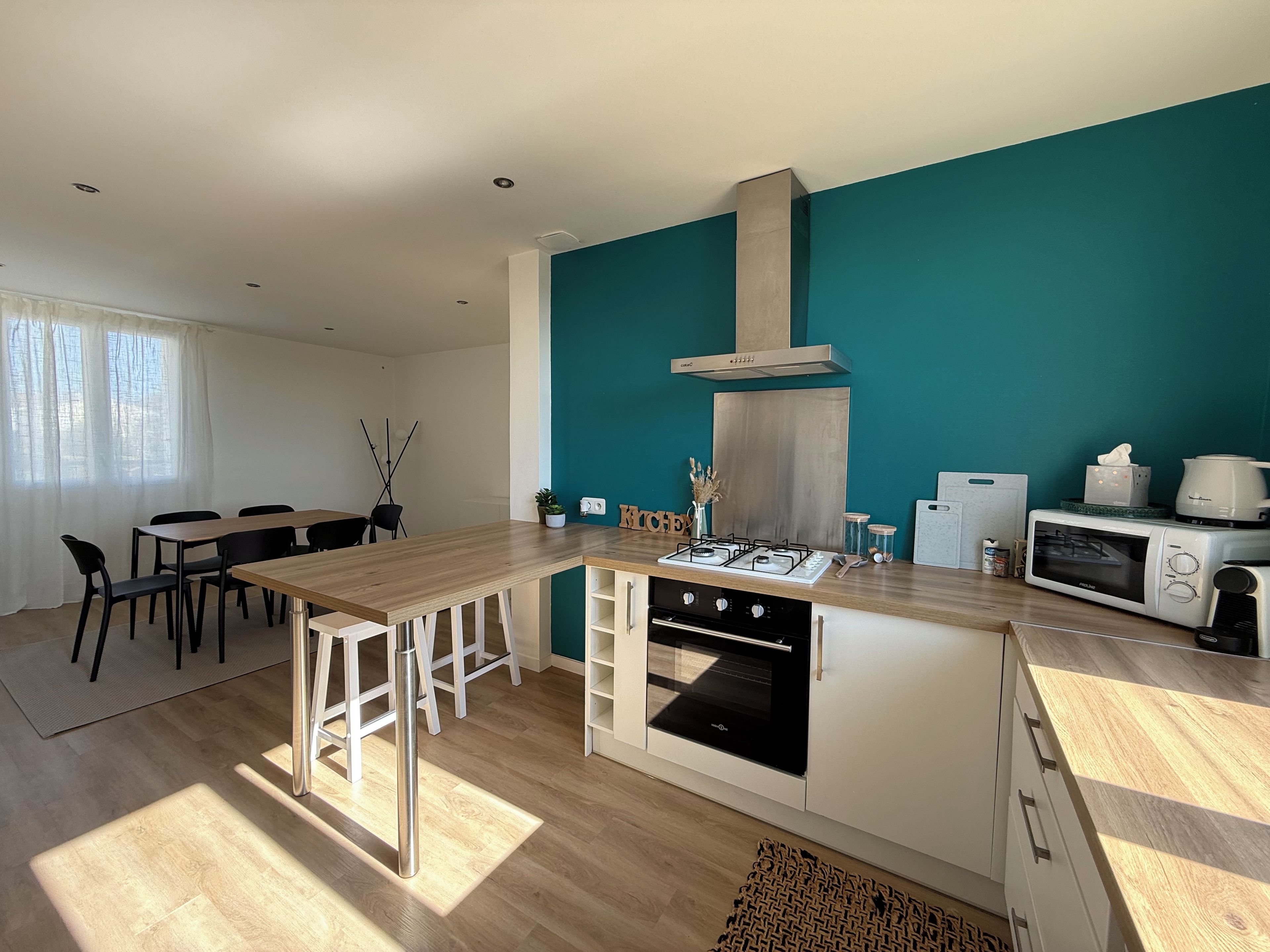 Una cocina moderna con una isla central, estufa a gas, microondas y horno empotrado.