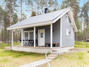 A small cabin with a porch, a door, and a chimney.