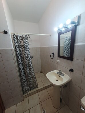 A bathroom with a shower, a sink, and a mirror with lights. - Marina Loft Studio # 218 (Del Coco Beach)