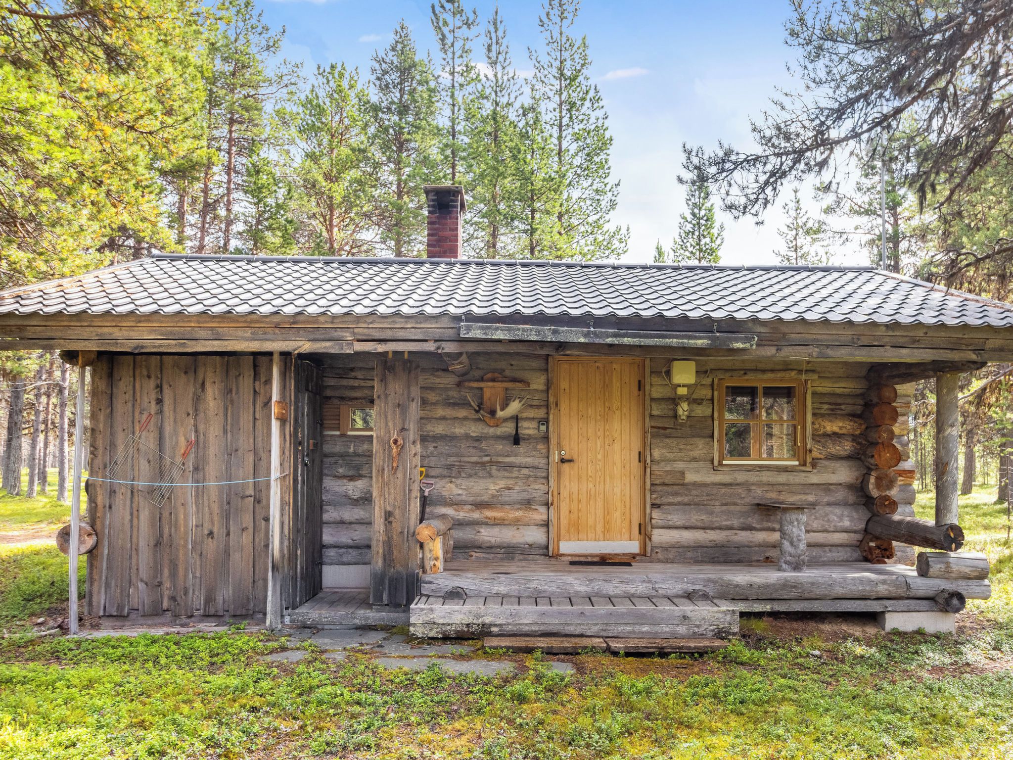 A rustic cabin with a wooden exterior, a tiled roof, and a front porch.