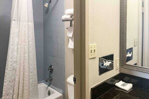 A bathroom with a shower, a toilet, a sink, and a mirror. - Comfy 2 Queen Bed|Fridge|Free Wifi (Stafford)