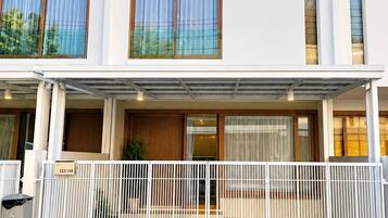 A modern two-story building with a covered entrance and a gated driveway.