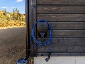 Ein tragbarer Elektrogenerator, der an einer Holzwand mit einem blauen Stromkabel befestigt ist.