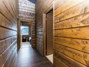 A narrow wooden hallway with a door leading to a bedroom. - Villa polar night by Interhome (Inari)