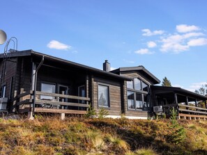 A modern log cabin with a deck, large windows, and a chimney. - Villa midnight sun by Interhome (Inari)