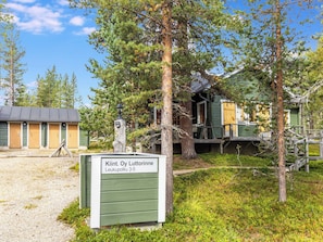 Eine Holzhütte mit einem Schild, das 'Kiint. Oy Luttorinne Leukupolku 3-5' anzeigt.