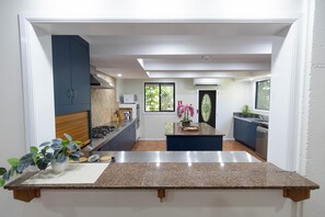 Una cocina moderna con encimeras de granito, una isla central y vistas al comedor.