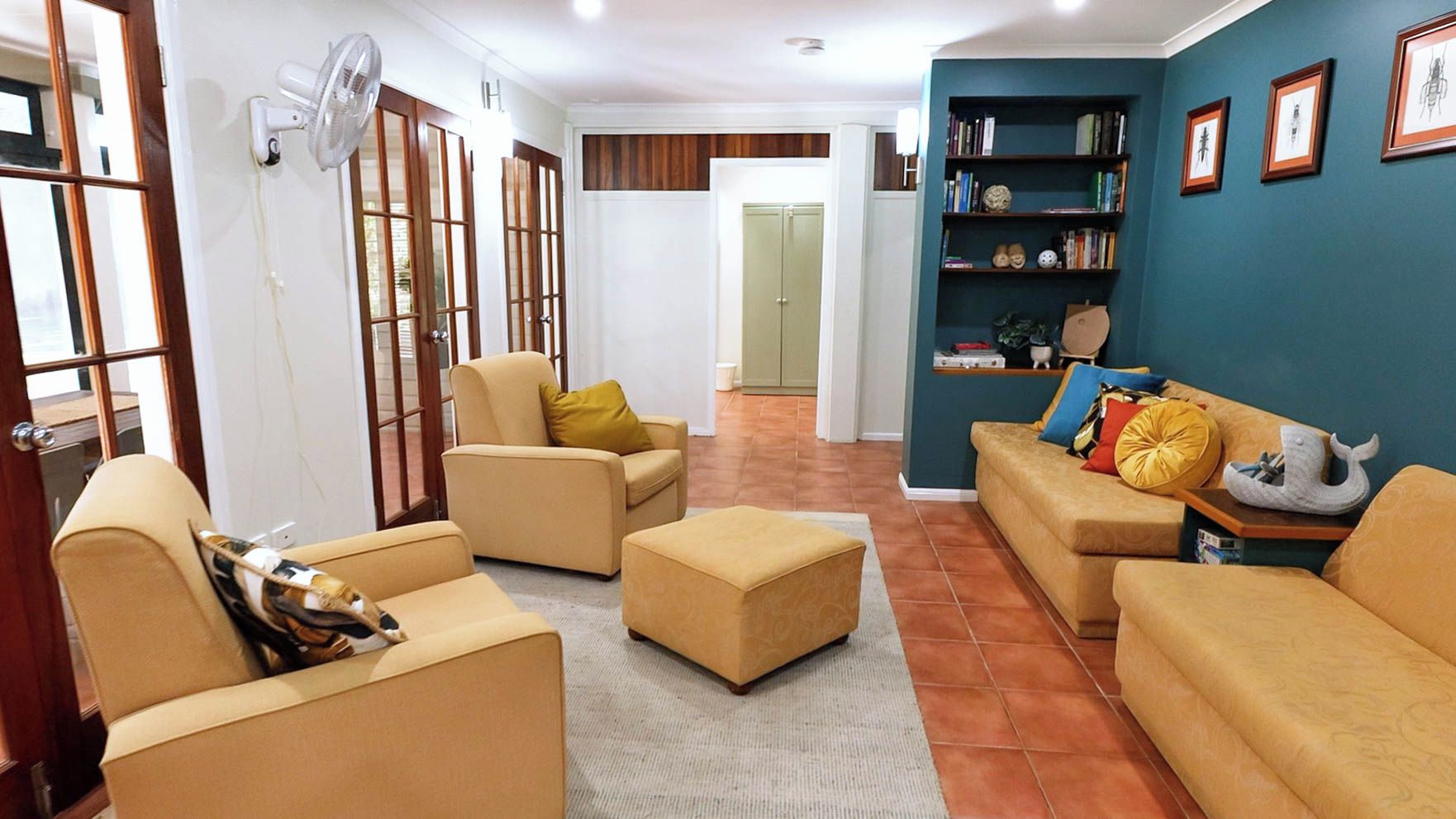 Un soggiorno con divani color beige, un tavolino da caffè e una libreria.