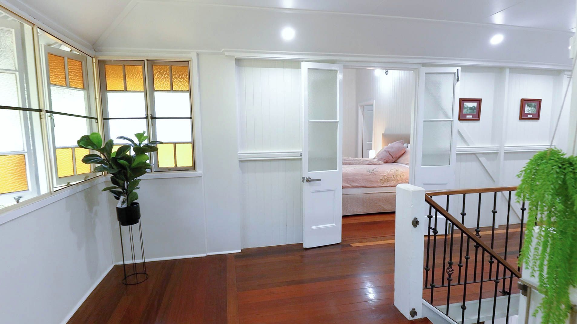 A room with a bed, a door, a staircase, and a window.