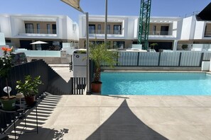 A swimming pool with a modern building in the background.