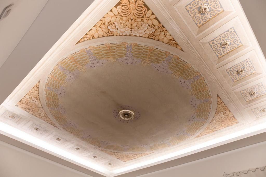A ceiling with ornate, symmetrical patterns and a central circular design.