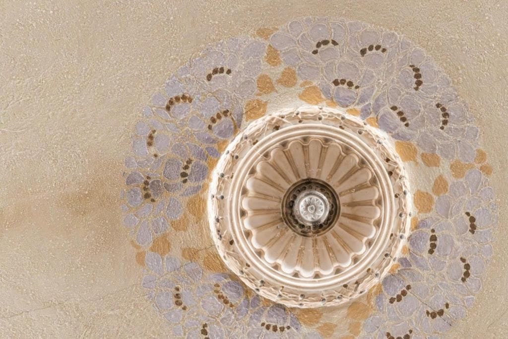 A spiral staircase with a decorative pattern on the wall.