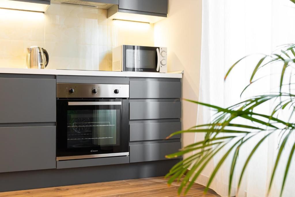 Una cocina moderna con electrodomésticos integrados, incluyendo un microondas y horno, y una encimera de madera.