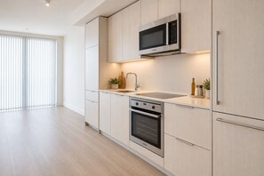 Eine moderne Küche mit einem Backofen von Bosch, einer Mikrowelle und einem Spülbecken.